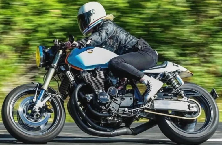 Gen Z rider on Yamaha custom café racer motorcycle, wearing helmet and leather jacket, speeding on highway with bikes.